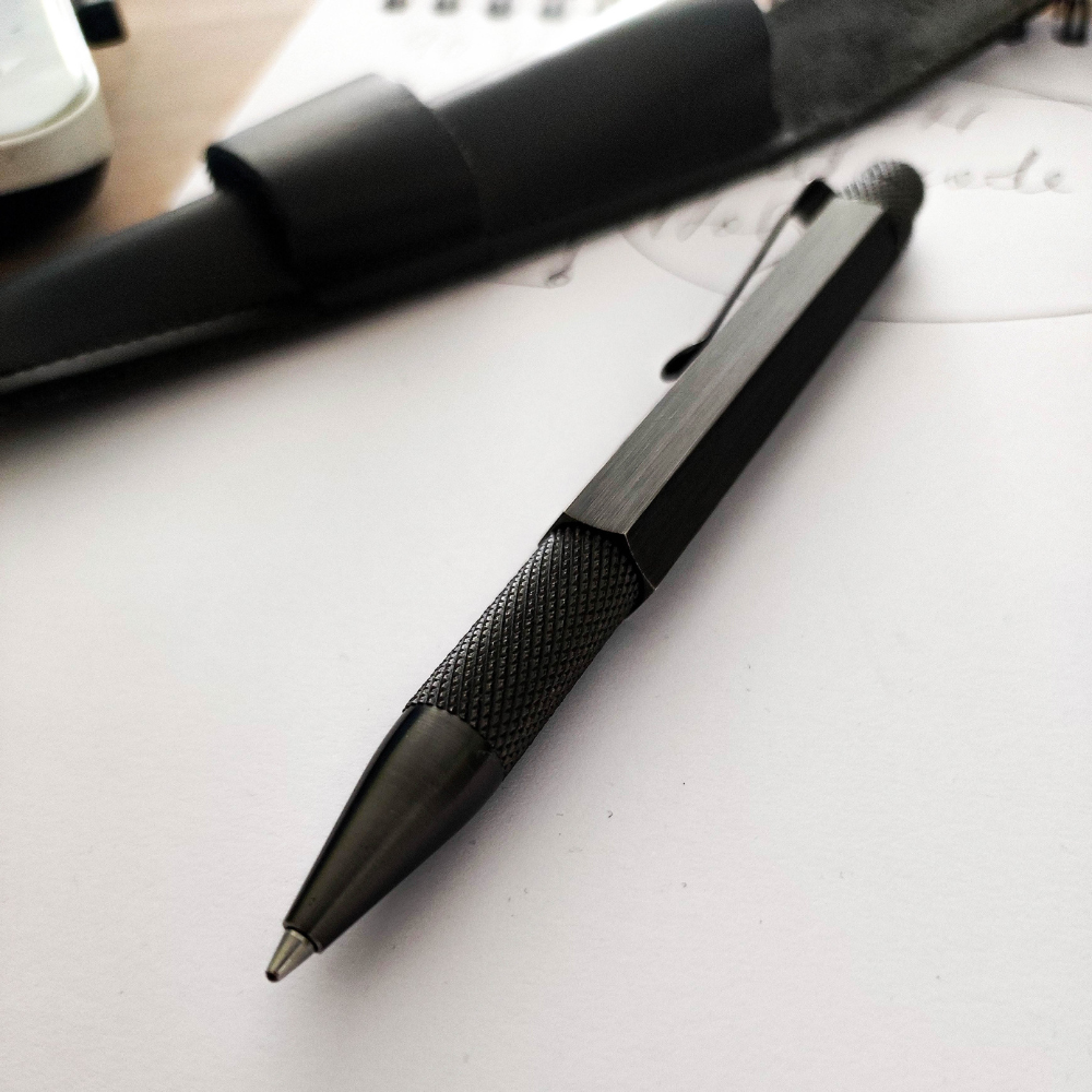 Loclen Black ballpoint pen with textured grip on a white surface