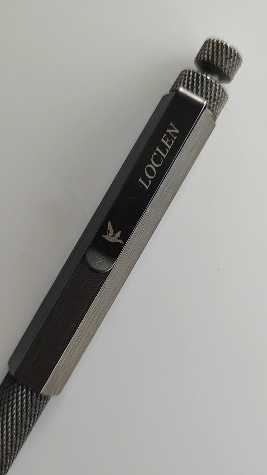 Matte black ballpoint pen sitting on a white surface